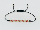 Pulsera Negra Con Ojitos Rojos Oro Laminado